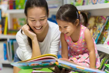 woman reading a book with child