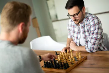 two adult men playing chess