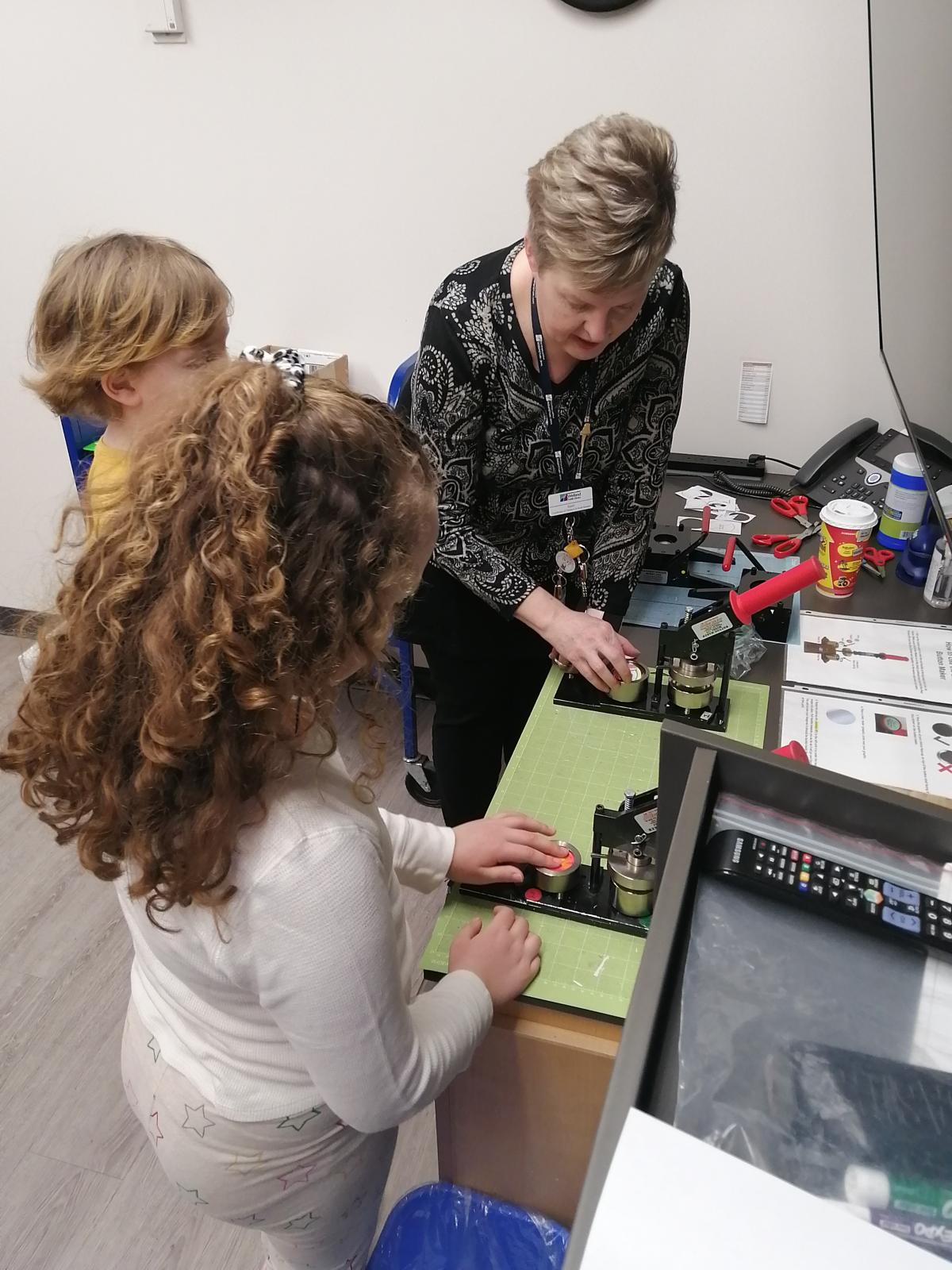 Children using a button maker